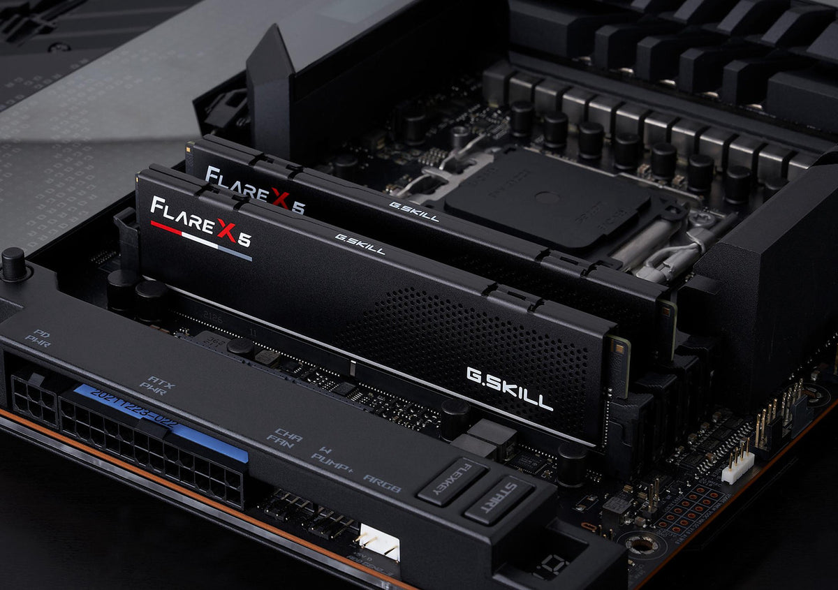 G.Skill Flare X6 RGB RGB DDR4 RAM sticks installed in a computer motherboard, shown in a close-up angle with black heat sinks and a dark circuit board background.